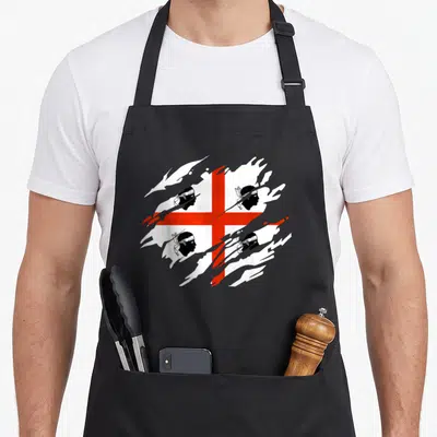 Tablier de cuisine noir avec le drapeau de la Sardaigne en croix rouge et silhouettes de têtes de Maures sur fond blanc déchiré.