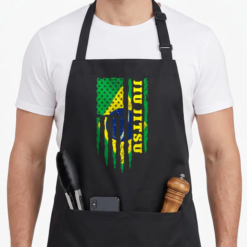 Tablier de cuisine noir avec un drapeau Brésilien et USA stylisé en griffures vertes et jaunes, texte JIU JITSU vertical jaune à droite.