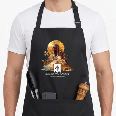 Tablier de cuisine noir avec illustration d'un empereur barbu en armure dorée, cavaliers et château fort au-dessus du texte Roads to Power.
