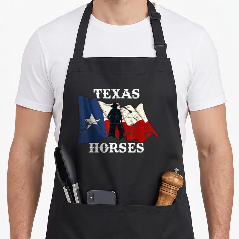 Tablier de cuisine noir avec drapeau texan et silhouette cow-boy portant l'inscription Texas Horses en blanc.