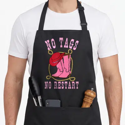 Tablier de cuisine noir avec inscription No Tags No Restarts, chapeau rouge et bottes roses entourées d'une corde jaune.
