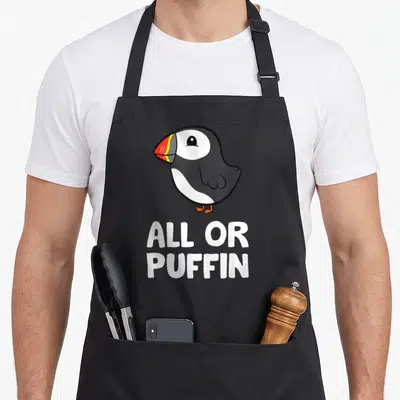 Tablier de cuisine noir avec illustration de puffin aux couleurs vives et texte blanc All Or Puffin en dessous.