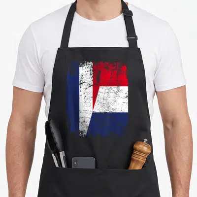 Tablier de cuisine noir avec un motif graphique combinant les couleurs du drapeau français et néerlandais dans un style usé et texturé.