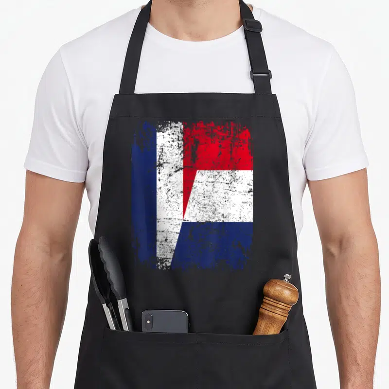 Tablier de cuisine noir avec un motif graphique combinant les couleurs du drapeau français et néerlandais dans un style usé et texturé.