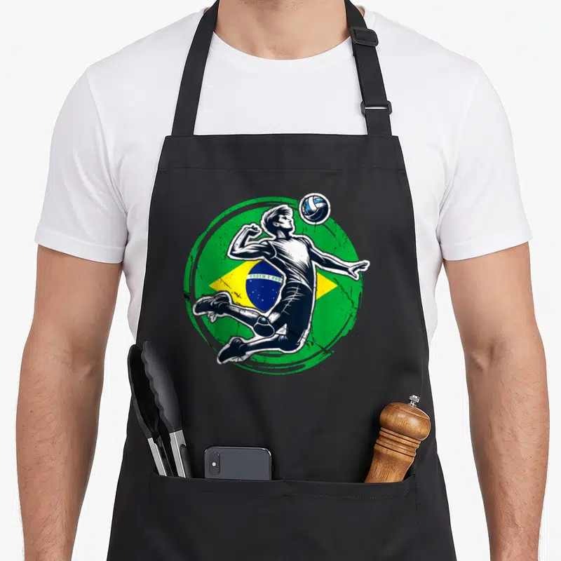Tablier de cuisine noir avec illustration d'un joueur de volleyball sautant devant le drapeau du Brésil.