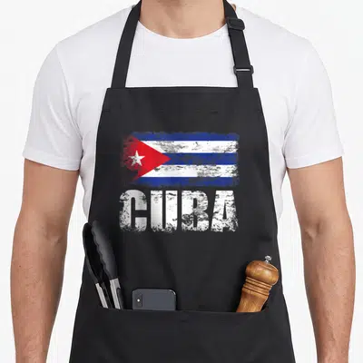 Tablier de cuisine noir avec illustration du drapeau Cuba et inscription CUBA en typographie blanche délavée.