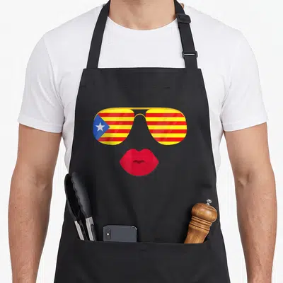 Tablier de cuisine noir avec lunettes aviateur au drapeau catalan et lèvres rouges stylisées.