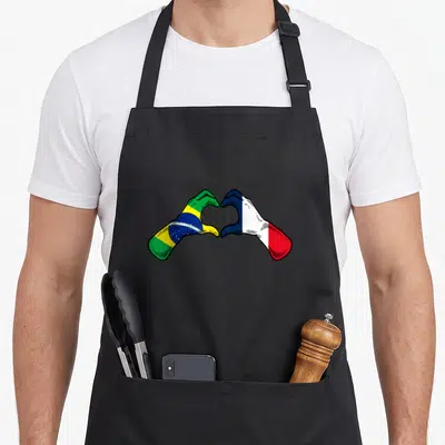 Tablier de cuisine noir avec deux mains formant un cœur aux couleurs des drapeaux brésilien et français.