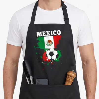Tablier de cuisine noir avec drapeau Mexico, ballon de football et éclaboussures de peinture aux couleurs nationales.
