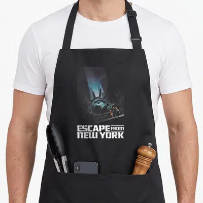 Tablier de cuisine noir avec une statue de la liberté renversée et des silhouettes entre les gratte-ciel.