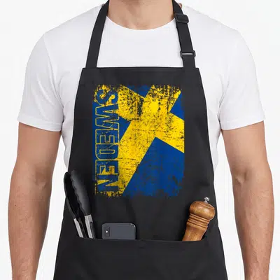 Tablier de cuisine noir avec drapeau Sweden bleu et jaune texturé et inscription verticale SWEDEN en lettres capitales bleues.
