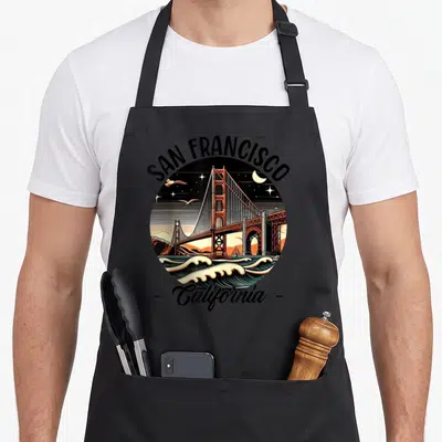 Tablier de cuisine noir avec illustration circulaire du Golden Gate Bridge, vagues, oiseaux et texte San Francisco California.