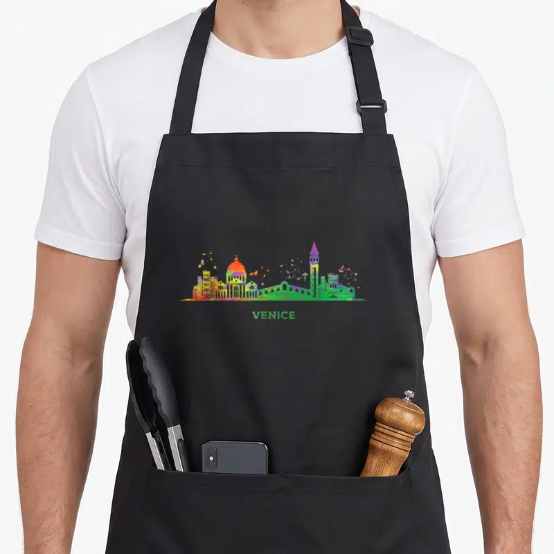 Tablier de cuisine noir avec un paysage urbain coloré de Venise et le texte VENICE en bas.