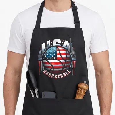 Tablier de cuisine noir avec un ballon de basket aux couleurs du drapeau USA et un skyline en arrière-plan.