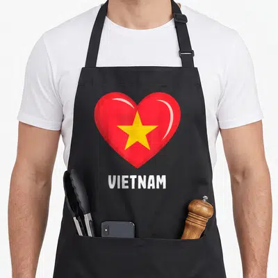 Tablier de cuisine noir avec un cœur rouge étoilé jaune et le texte VIETNAM en bas.