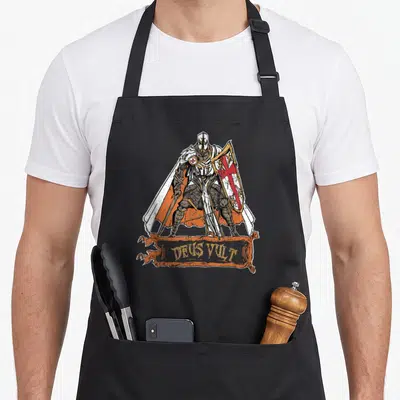 Tablier de cuisine noir avec illustration d'un guerrier Templiers en armure et drapeau orange portant l'inscription Deus Vult.