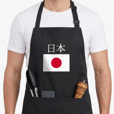 Tablier de cuisine noir avec le drapeau Japon et les caractères chinois blancs au centre.