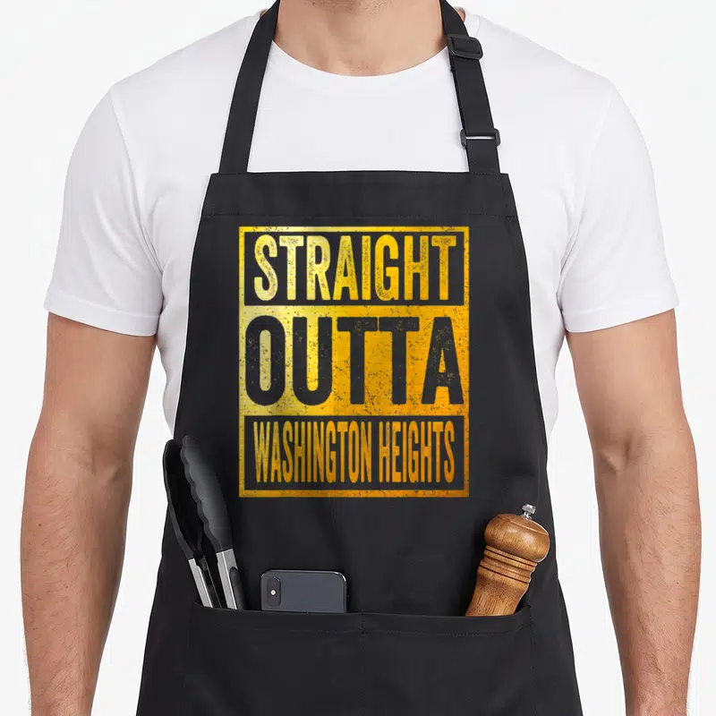 Tablier de cuisine noir avec inscriptionStraight Outta Washington Heights en jaune et gris sur fond texturé.