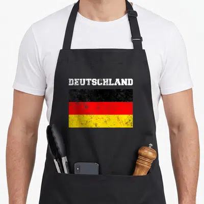 Tablier de cuisine noir avec l'inscription Deutschland et le drapeau allemand aux couleurs noires, rouges et jaunes en style vintage.