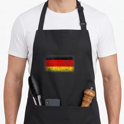 Tablier de cuisine noir avec drapeau Allemagne Deutschland style usé aux trois bandes horizontales.