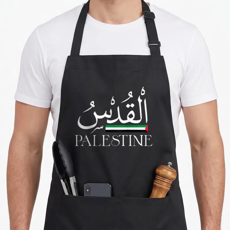 Tablier de cuisine noir avec calligraphie Al Quds, drapeau palestinien et mot Palestine en blanc.