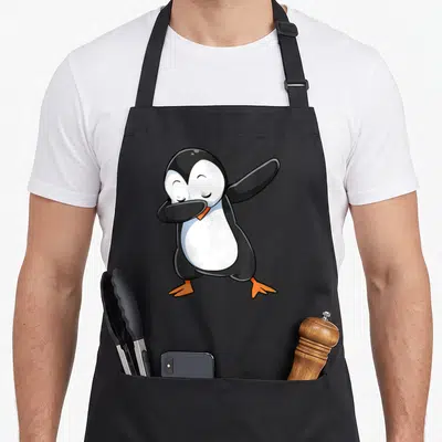 Tablier de cuisine noir avec un pingouin noir et blanc effectuant une pose dab souriante.