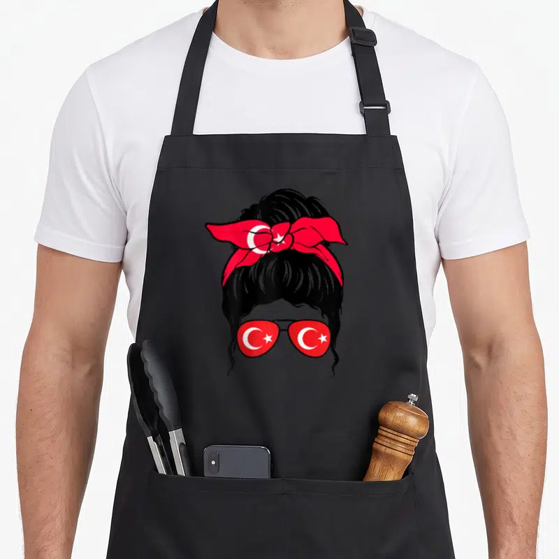 Tablier de cuisine noir avec illustration de femme aux verres de lunettes ornés du croissant et de l'étoile turcs.