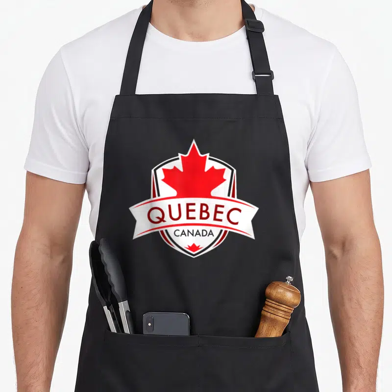 Tablier de cuisine noir avec logo shield Québec Canada et feuille d'érable rouge centrale.