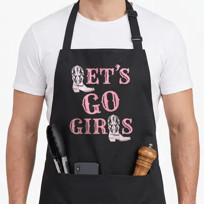 Tablier de cuisine noir avec texte rose Let's Go Girls et illustrations de bottes de cowgirl