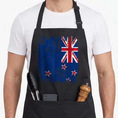 Tablier de cuisine noir avec drapeau Nouvelle-Zélande style vintage et étoiles rouges.