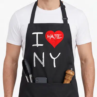Tablier de cuisine noir avec un cœur rouge et le texte blanc I HATE NY en style graffiti.