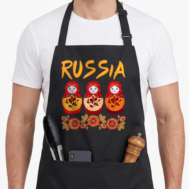 Tablier de cuisine noir avec trois matriochkas rouges et le mot RUSSIA en orange