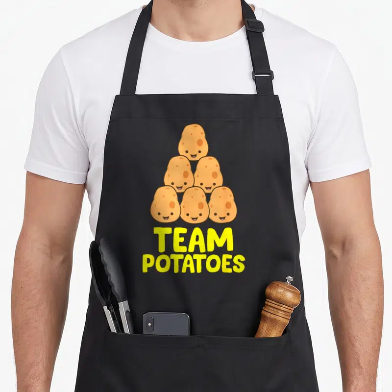 Tablier de cuisine noir avec six patates mignonnes en pyramide et l'inscription Team Potatoes en lettres jaunes.