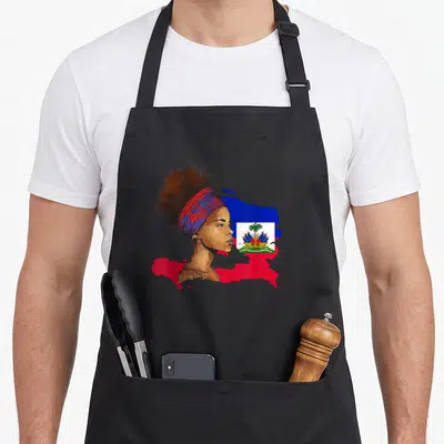 Tablier de cuisine noir avec une femme haïtienne de profil et le drapeau du pays imprimé en couleur.