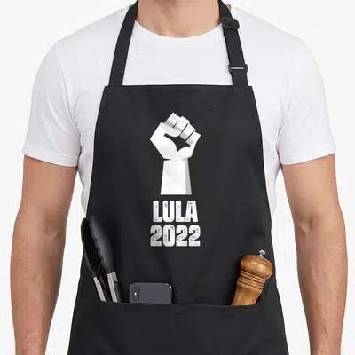 Tablier de cuisine noir avec un poing levé blanc et les mots Lula 2022 imprimés en dessous.