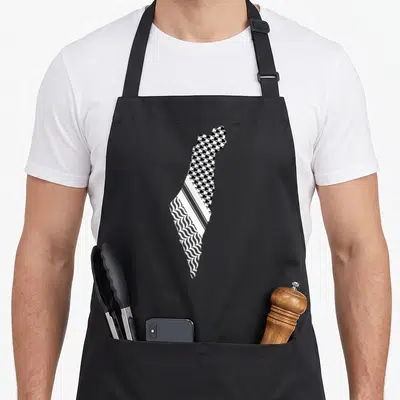 Tablier de cuisine noir avec une carte de Palestine remplie de motifs de keffiyeh et les mots Free Palestine Gaza Arabic imprimés.