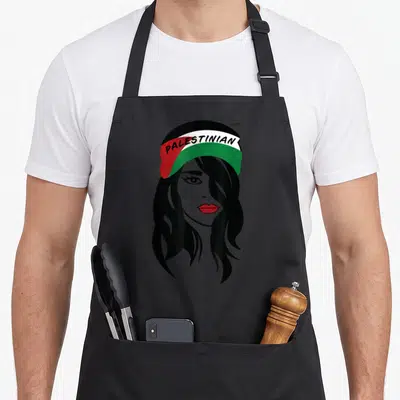 Tablier de cuisine noir avec illustration d'une femme palestinienne au bandana tricolore et lèvres rouges.
