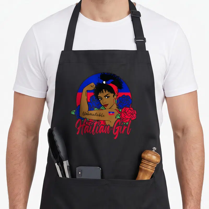 Tablier de cuisine noir avec illustration d'une femme forte, des roses et l'inscription Haitian Girl sur fond de drapeau haïtien.