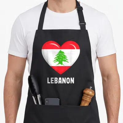 Tablier de cuisine noir avec un grand cœur rouge et blanc contenant un cèdre vert et le texte Lebanon en bas.