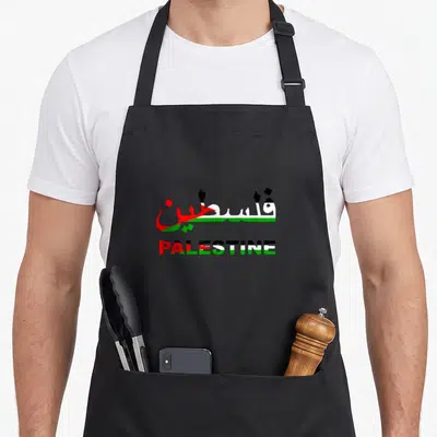 Tablier de cuisine noir avec l'inscription Palestine en lettrage tricolore et calligraphie arabe rouge verte et noire.