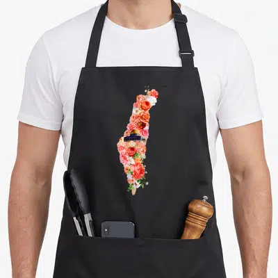 Tablier de cuisine noir avec une carte de Palestine formée de roses orangées et du dôme doré.