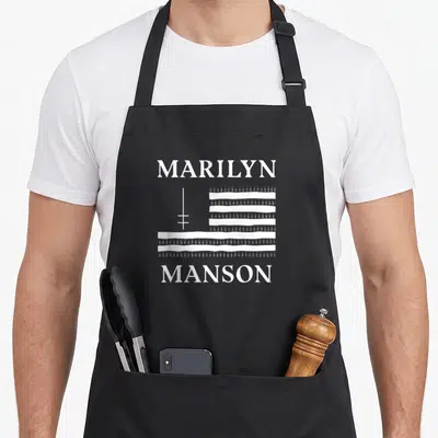 Tablier de cuisine noir avec le drapeau et le logo de Marilyn Manson imprimés en blanc au centre.