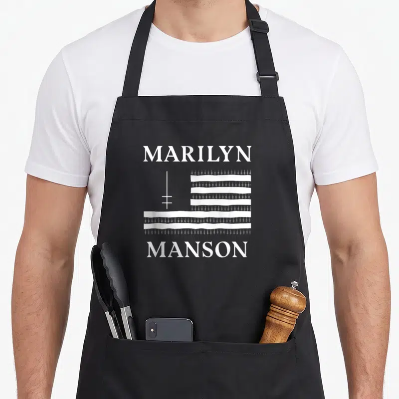 Tablier de cuisine noir avec le drapeau et le logo de Marilyn Manson imprimés en blanc au centre.
