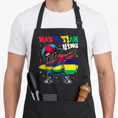 Tablier de cuisine noir avec illustration d'un Roi mauricien en train de faire le dabing devant un drapeau aux couleurs vives.