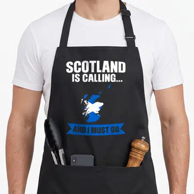 Tablier de cuisine noir avec carte Écosse bleue et texte blanc Scotland is calling and I must go sur banderole.
