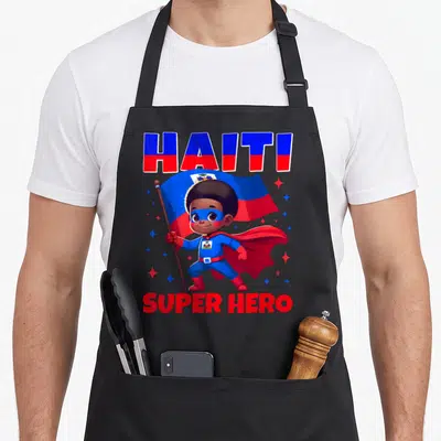 Tablier de cuisine noir avec un super héros haïtien tenant le drapeau bleu et rouge sous les mots HAÏTI et SUPER HERO.