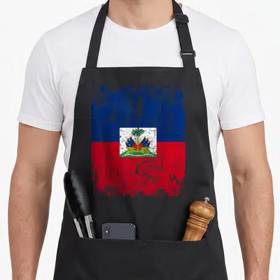 Tablier de cuisine noir avec drapeau Haïti style vintage et emblème central coloré.