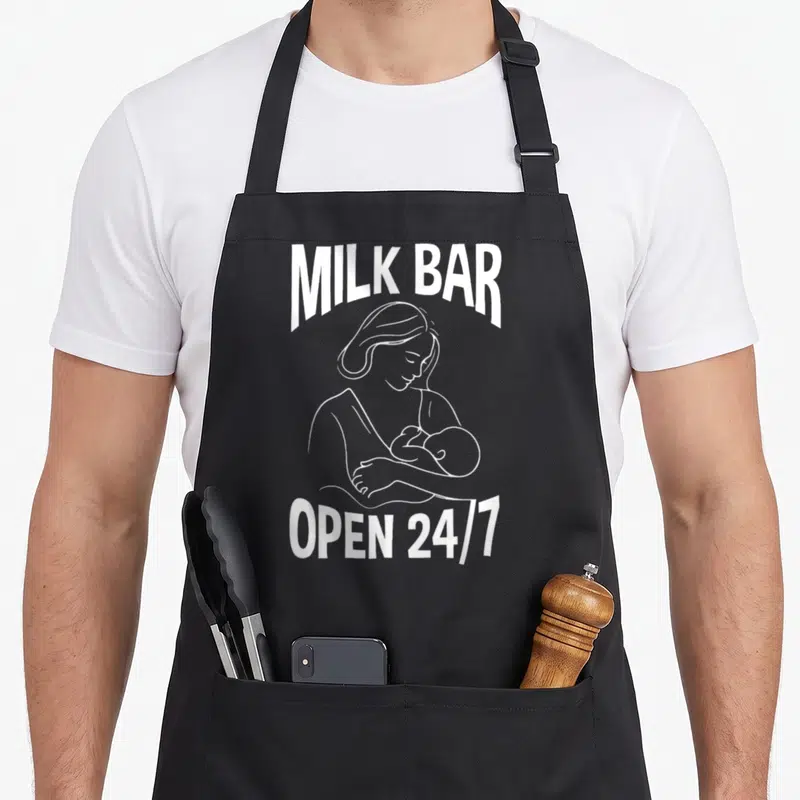 Tablier de cuisine noir avec illustration blanche d'une maman allaitant et le texte Milk Bar Open 24/7.