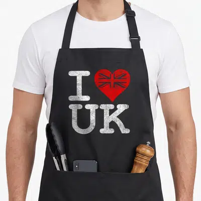 Tablier de cuisine noir avec un cœur rouge et les lettres I UK en blanc texturé.