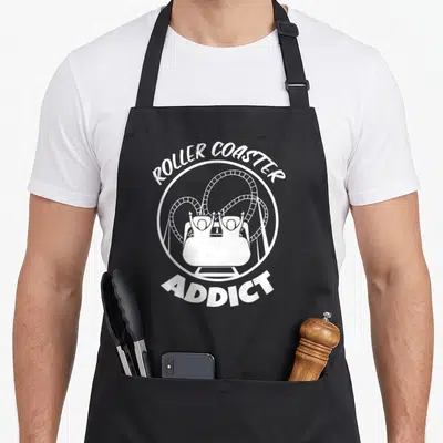 Tablier de cuisine noir avec illustration blanche d'un train de montagnes russes et du texte Roller Coaster Addict.